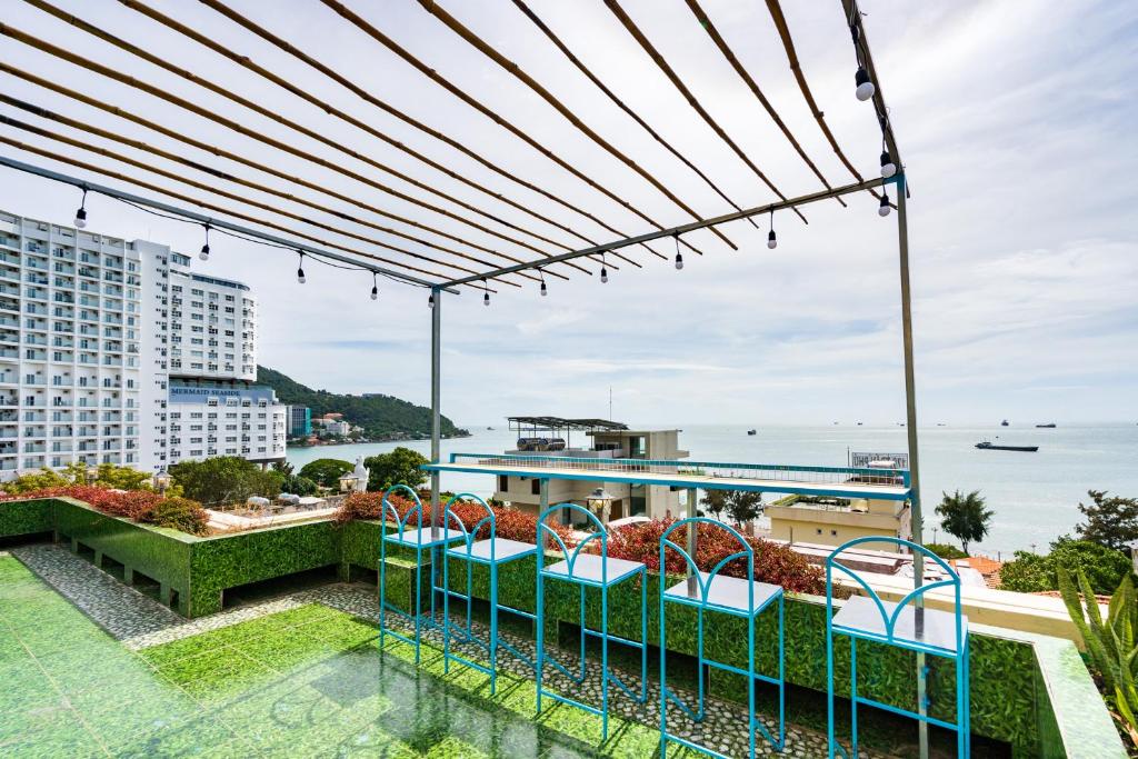 头顿Sunset Bãi Dâu Boutique Hotel Vũng Tàu的阳台配有椅子,享有海景。