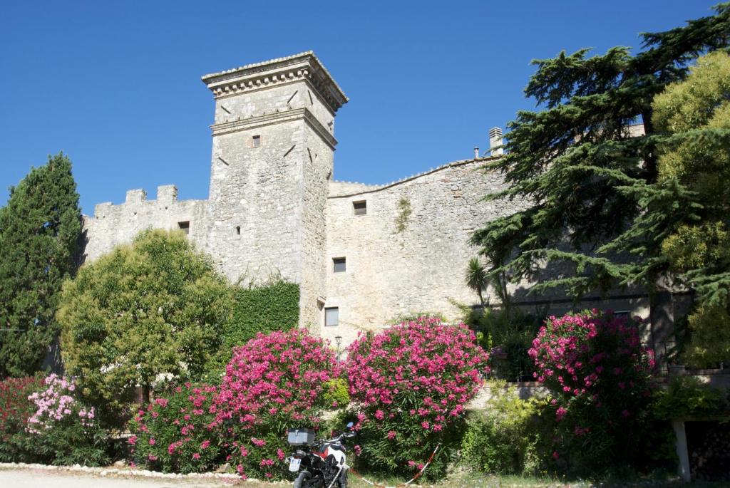 托迪Torre Sangiovanni Albergo e Ristorante da Rosary的一座城堡,在一座建筑前有粉红色的花朵
