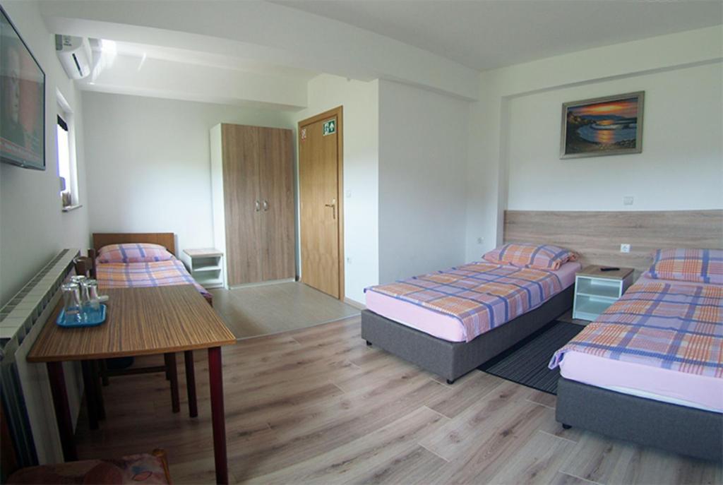 别洛瓦尔Sobe Mrak的酒店客房设有两张床和一张桌子。