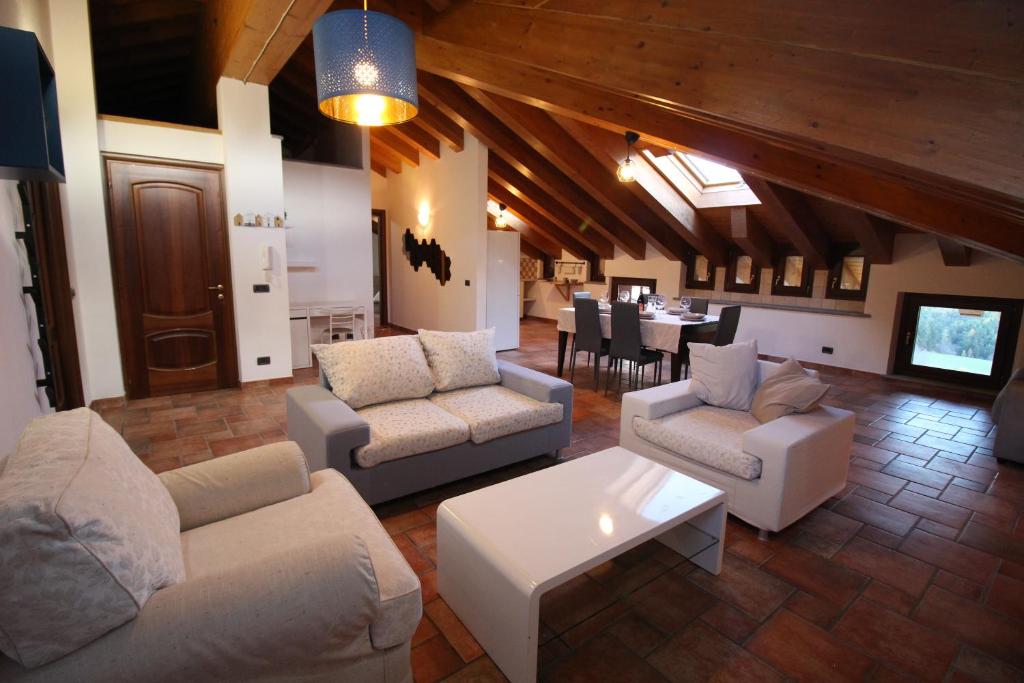 布吕松Attico dell'Aquila的带沙发的客厅和用餐室