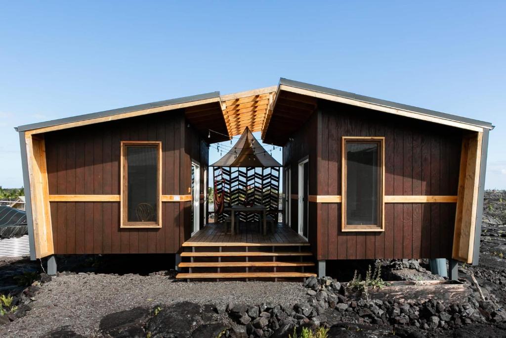 KehenaTHE OHANA HOUSE, Amazing Tiny Home on A Volcanic Lava Field!的一个小房子,设有门廊和楼梯