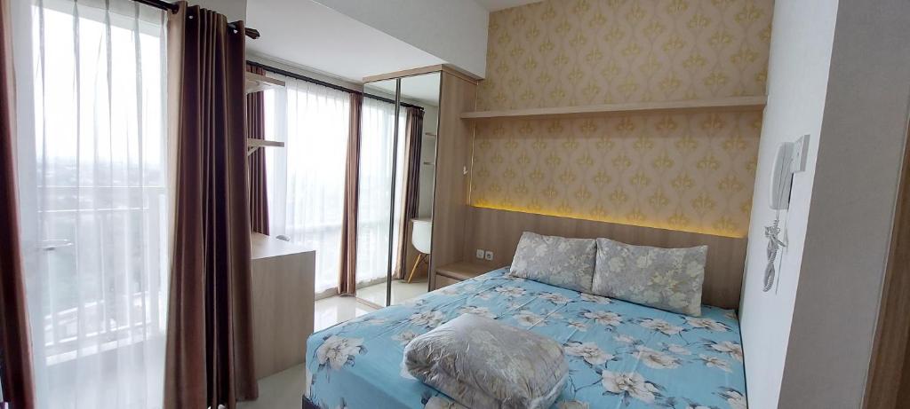 斯勒曼Apartemen Taman Melati Yogyakarta by ArFe Room的一间卧室设有蓝色的床和窗户。