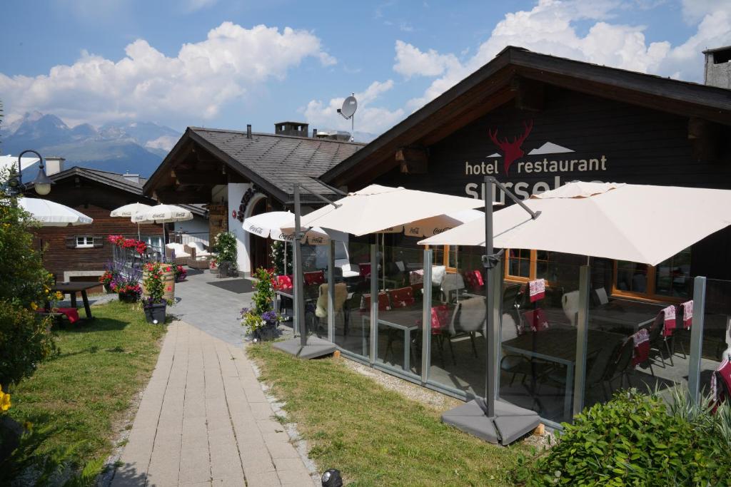 Surcuolm苏尔塞瓦酒店的前面有白色遮阳伞的餐厅