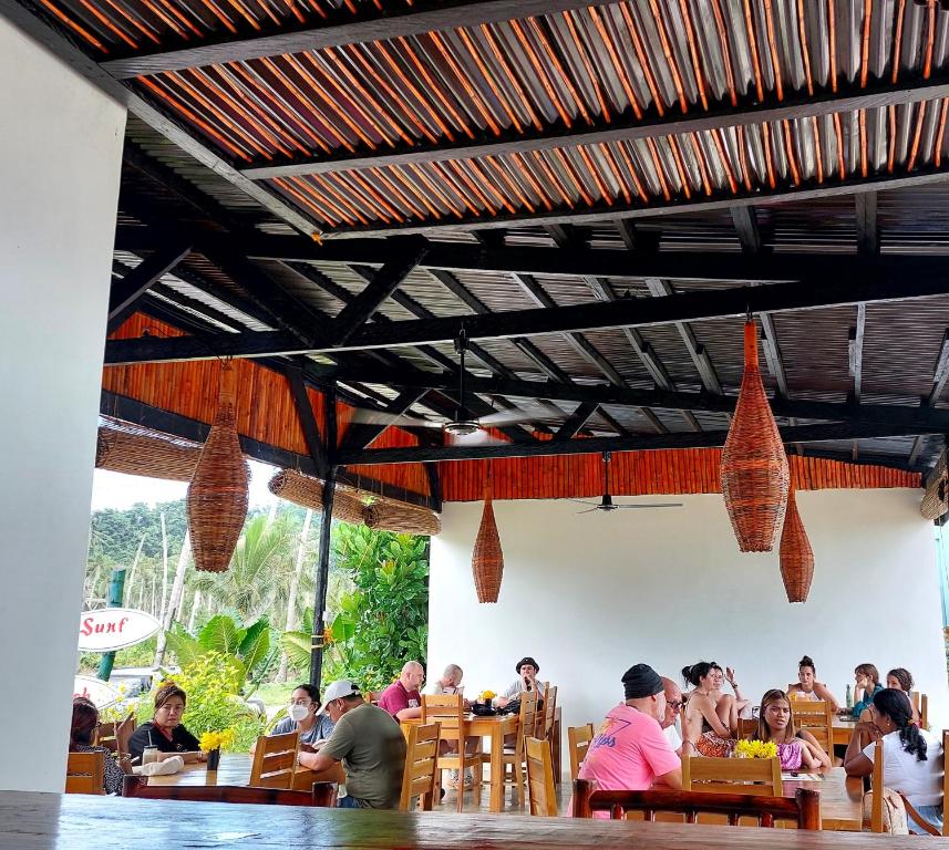 San IsidroBamboo Surf Beach的一群坐在餐厅桌子上的人