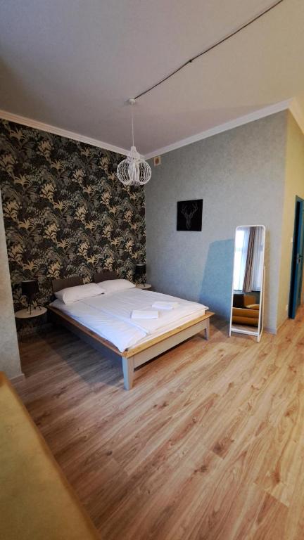 格鲁德柴兹Villa Grudziądz的一间卧室设有一张大床,铺有木地板