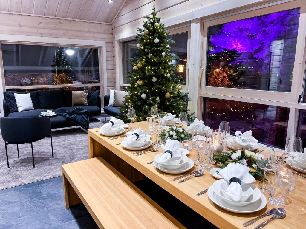 罗瓦涅米Santa's Luxury Boutique Villa, Santa Claus Village, Apt 2的一张餐桌,在房间内摆放着圣诞树