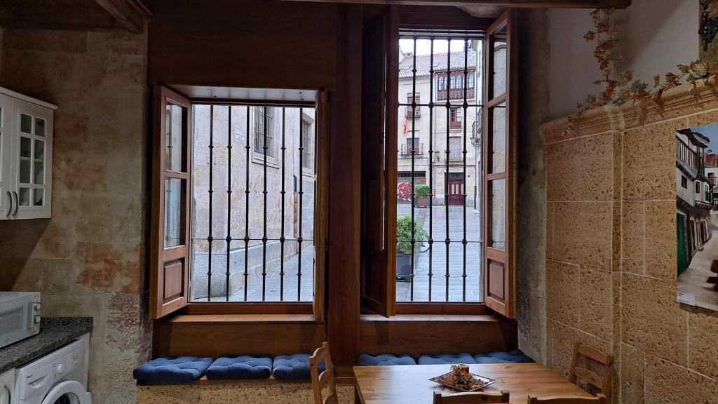 萨拉曼卡LAS CATEDRALES De SALAMANCA的客房设有2扇窗户和桌椅。