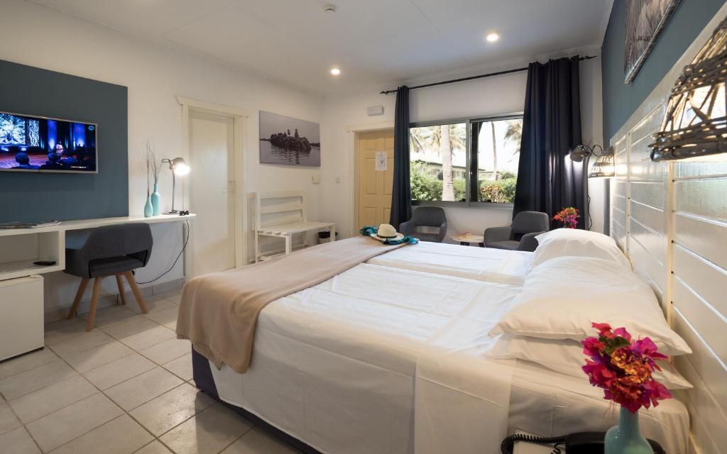 Sere Kunda NDingSunset Beach Hotel的酒店客房设有一张白色大床和一张书桌