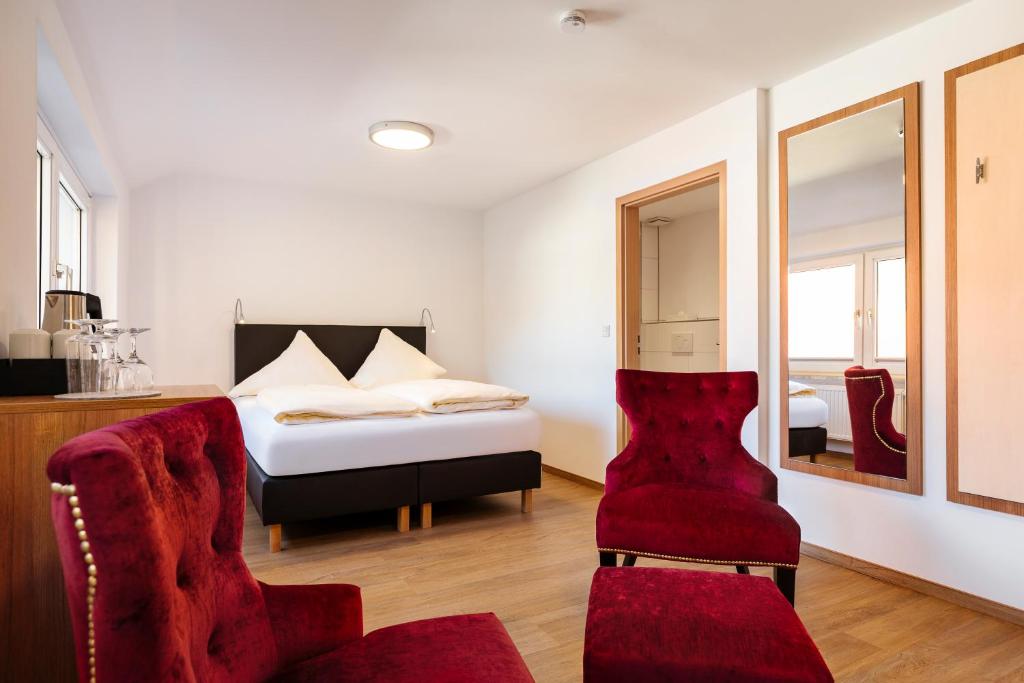 黑尔戈兰岛Helgolandia Dependance的一间卧室配有一张床和一张红色椅子