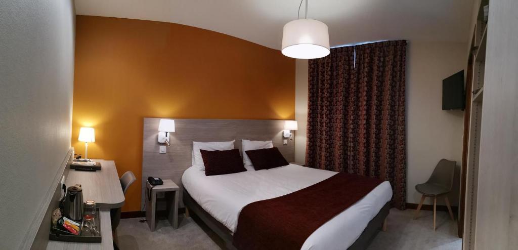 圣让德莫里耶讷圣特乔治酒店的酒店客房设有一张大床和一张书桌。