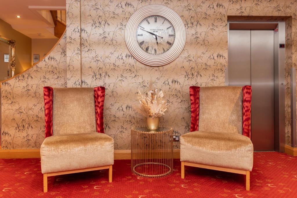 贝尔法斯特塔拉旅馆的墙上有两把椅子和一个钟