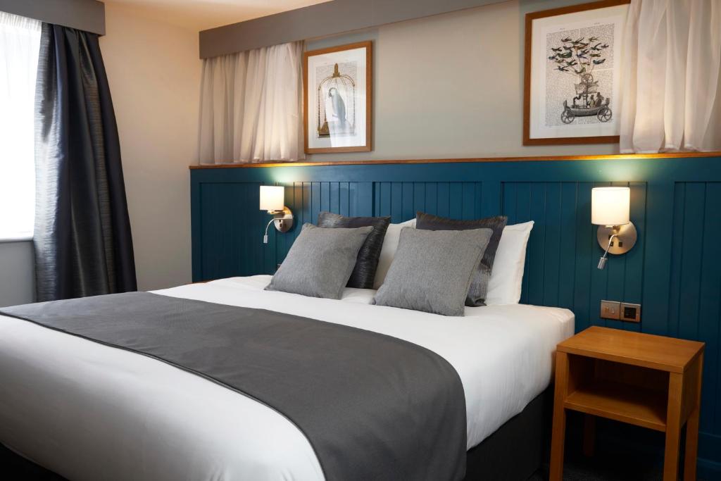 韦克菲尔德Holmfield Arms by Greene King Inns的一间卧室设有一张蓝色墙壁的大床