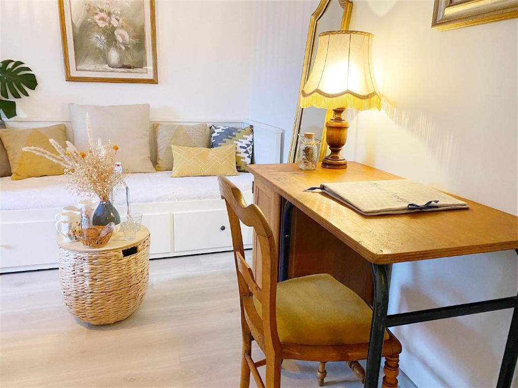 迪塞L'Autre Rivière - Chambres d'hôtes的客房设有带台灯和沙发的书桌。