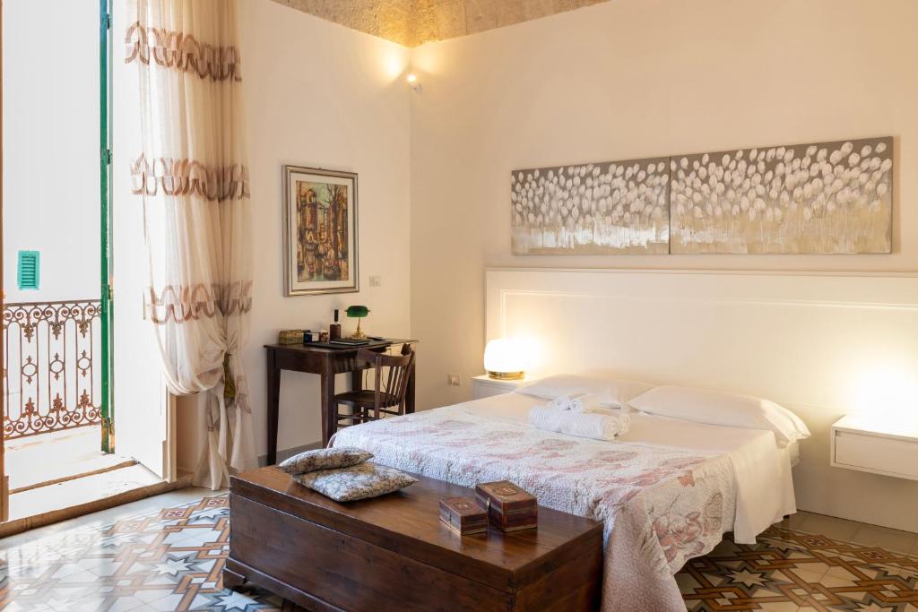 滨海波利尼亚诺WePuglia - Catarì的一间卧室配有一张床、一张桌子和一个窗户。