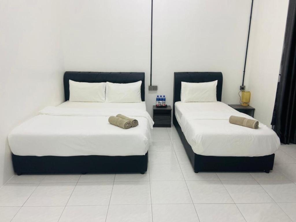 Kampong BembanI-STAY 01 JK Roomstay的两张睡床彼此相邻,位于一个房间里