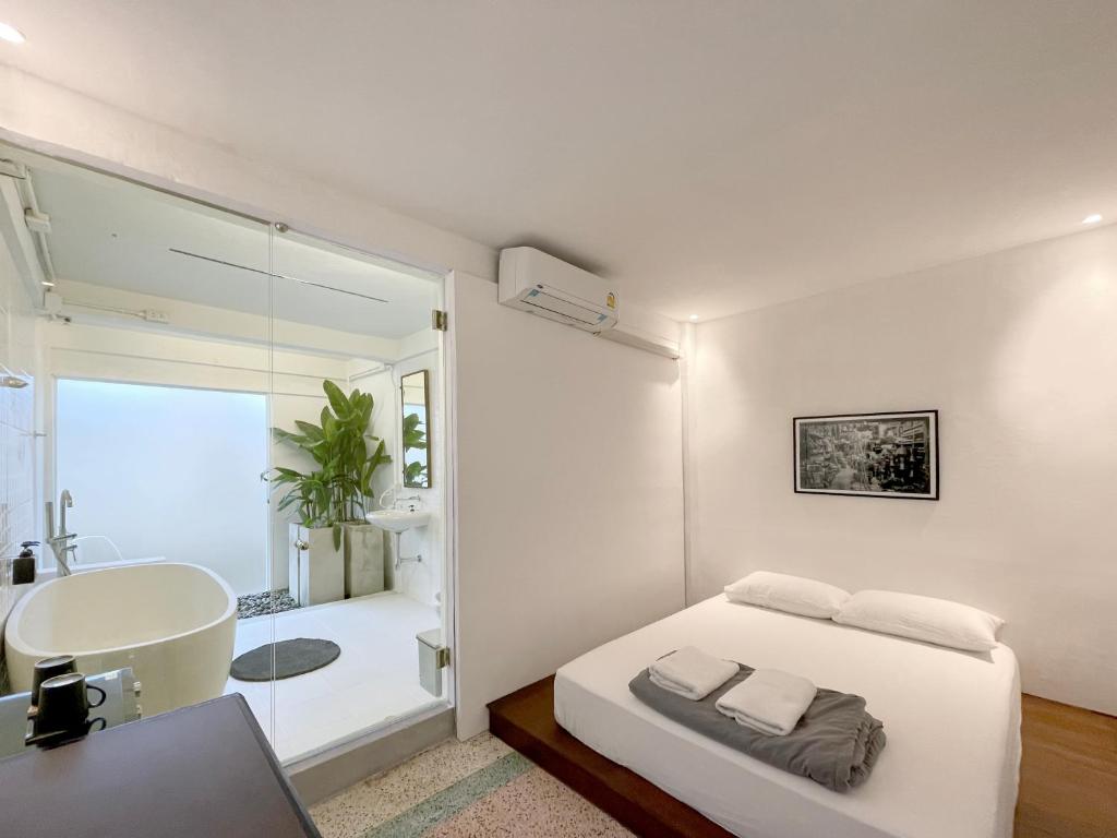 邦拉Chatel BKK的一间卧室配有一张床和一个水槽和一个浴缸