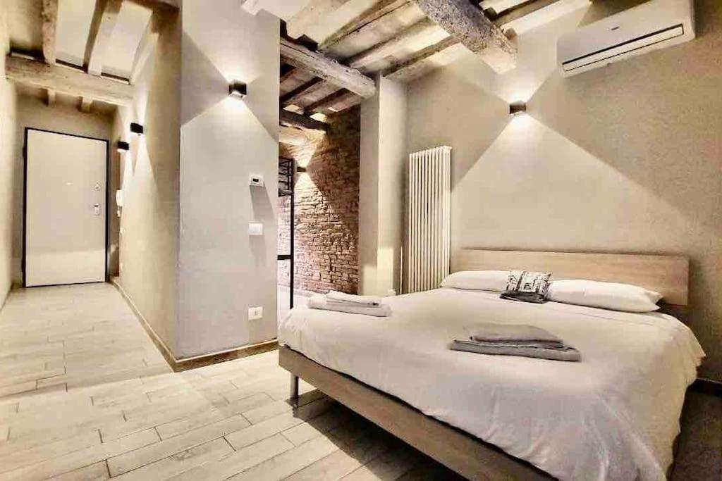 帕尔马Luxury Home in Centro Da Marghe by Revenue House的一间卧室设有一张大床和砖墙