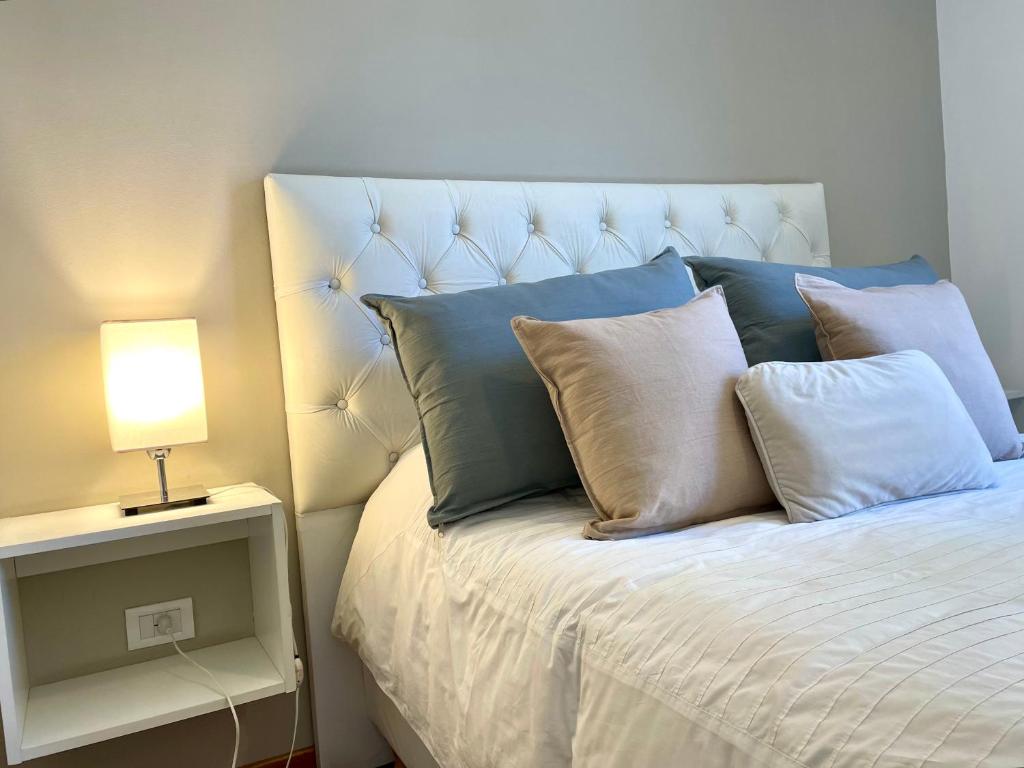 科尔多瓦巴尔卡斯豪华公寓的一张带蓝色和白色枕头的床和一盏灯