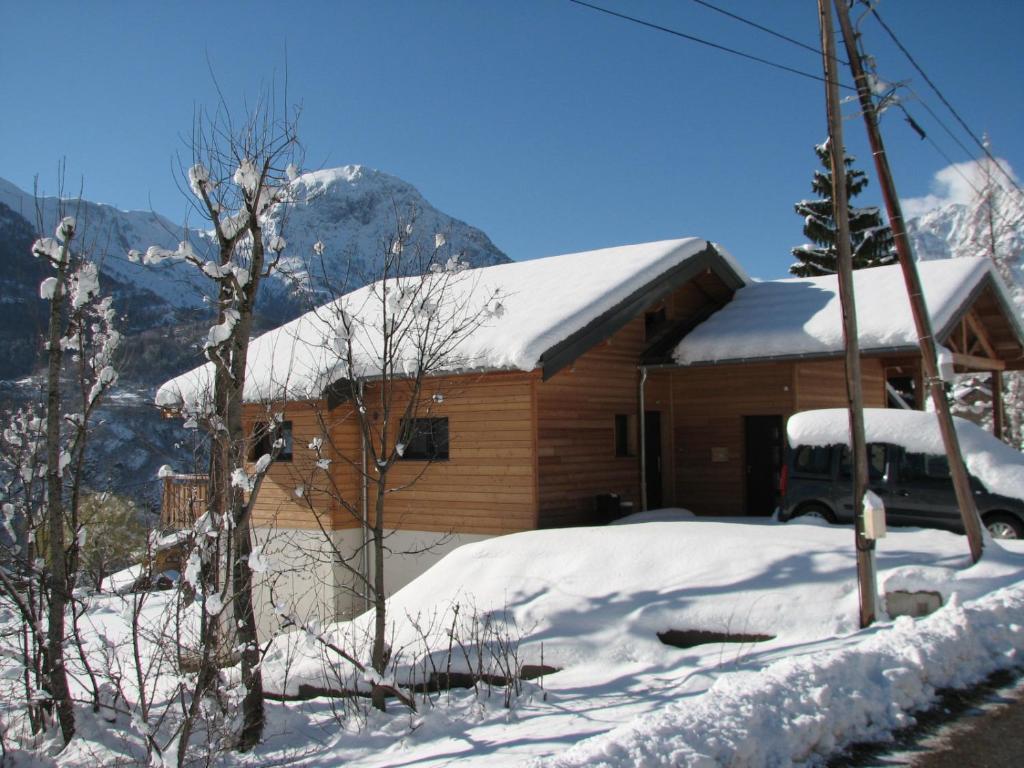奥瑞斯Chalet de l'Infernet的屋顶上积雪的小屋和前方的停车场