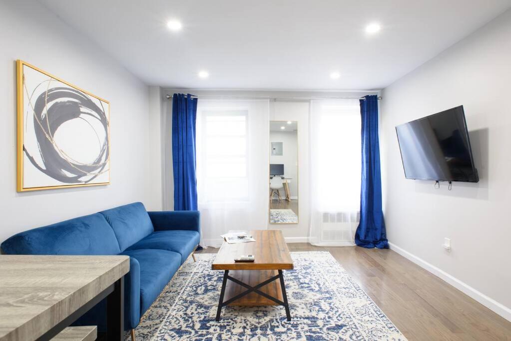 纽约350-2A Prime gramercy Newly renovated 1BR sleeps 4的客厅配有蓝色的沙发和电视