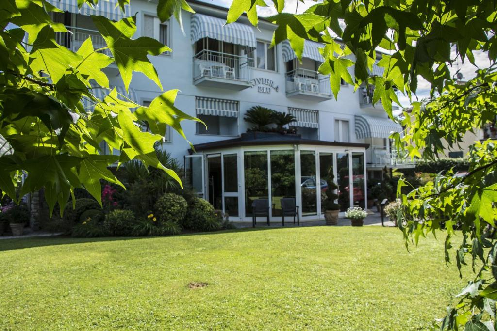 蒂勒尼亚里维埃拉布鲁酒店的前面有草坪的建筑