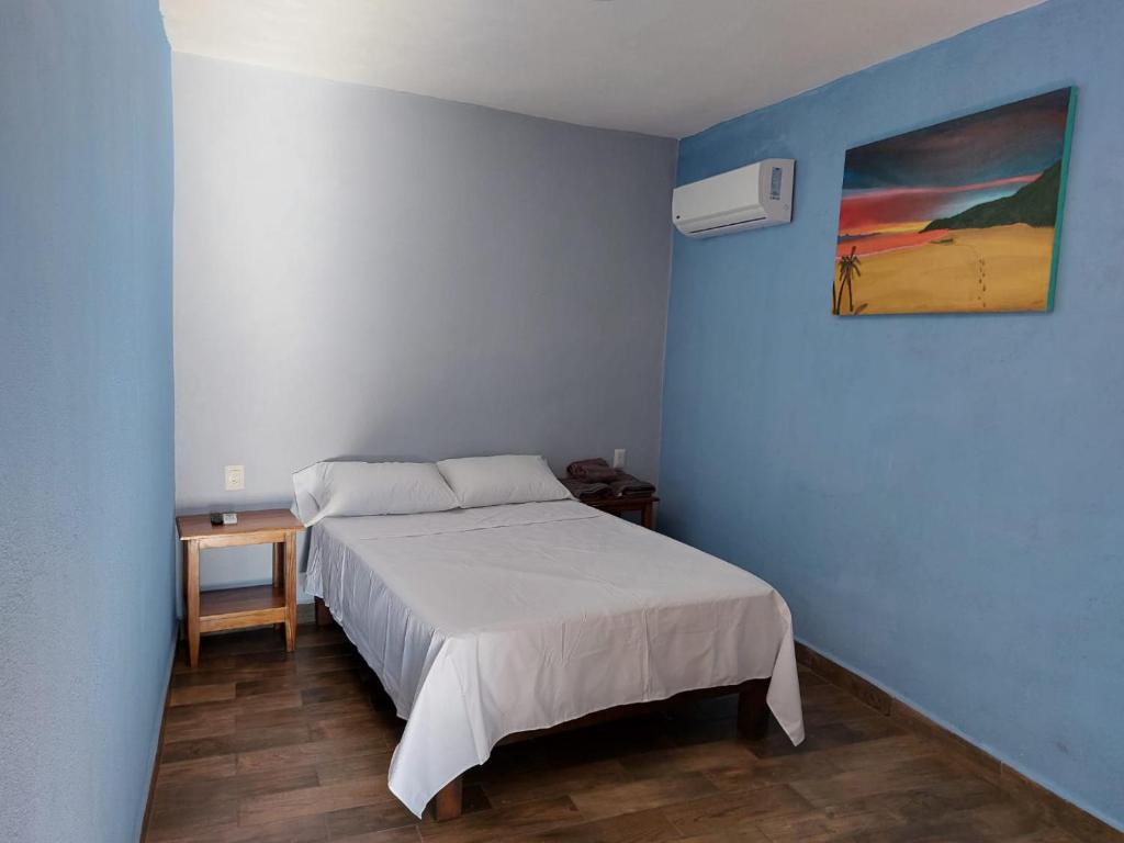Barrio NuevoLA CASA AZUL DE SAMARA的卧室配有一张床,墙上挂有绘画作品