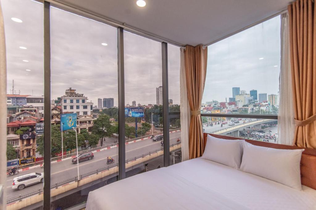 河内Coco Hotel Cau Giay的一间卧室设有一张床和一个大窗户
