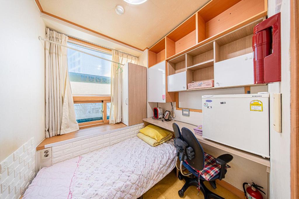 首尔Dream Single House的一间带床和冰箱的小卧室