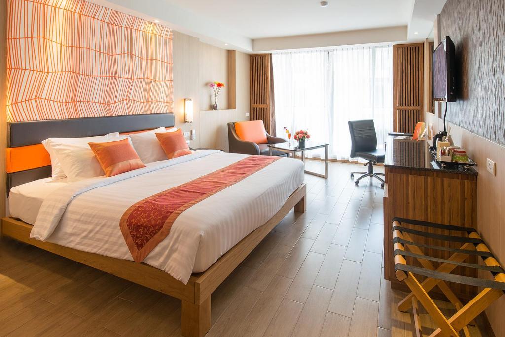 曼谷王朝格兰德酒店（原王朝格兰德旅馆）的一间卧室配有一张大床和一张桌子及椅子