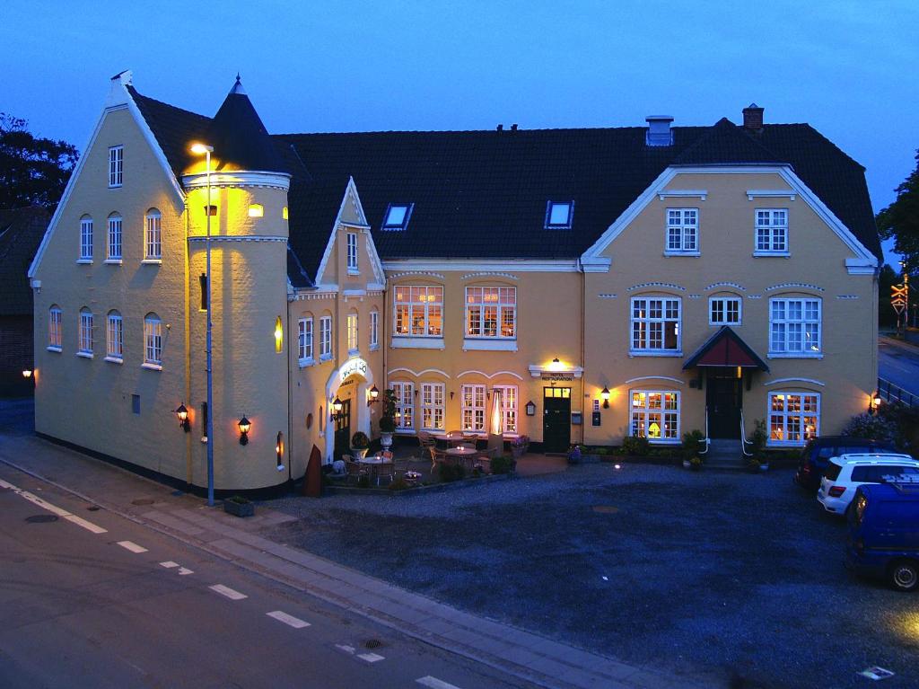 霍伊斯莱乌霍兹勒维酒店的前面有一辆汽车停放的大房子