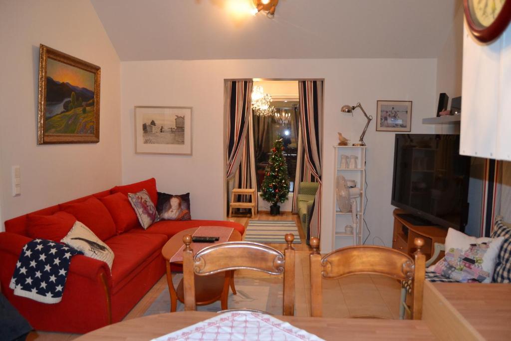 LöparöVilla Linnunlaulu的客厅配有红色的沙发和圣诞树