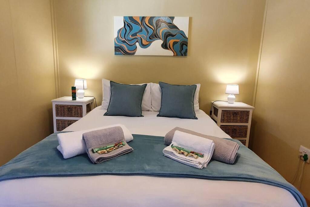 塞昆达Jakaranda Cabin - Self Catering Apartment的一间卧室配有一张带两个枕头的床