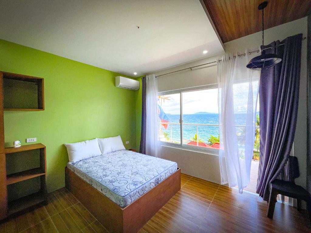 马比尼Anilao Ocean View Guest House的一间卧室设有一张床和一个大窗户