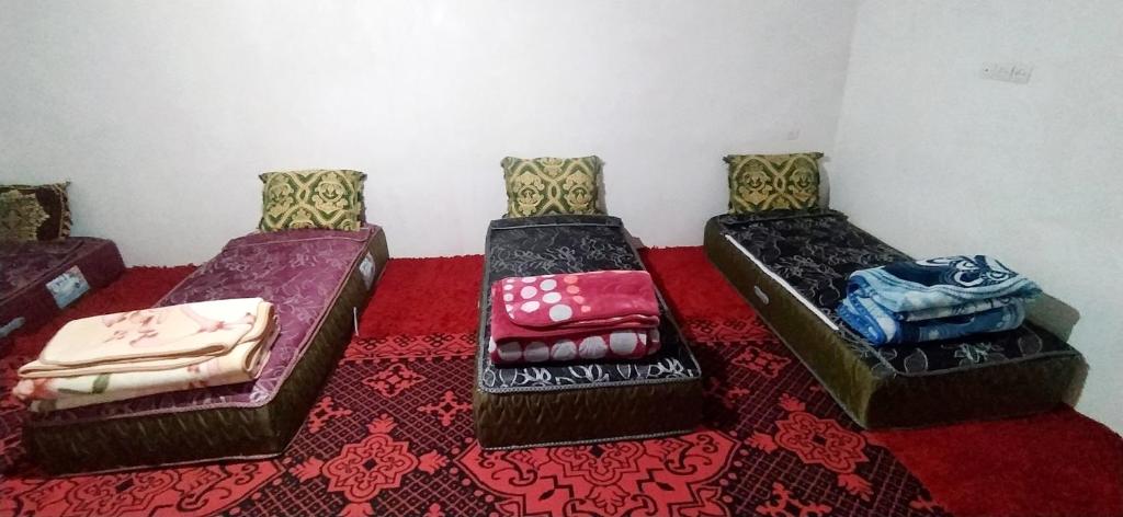 米德勒特Gite taouraout的一张三床,坐在一间铺有红地毯的房间