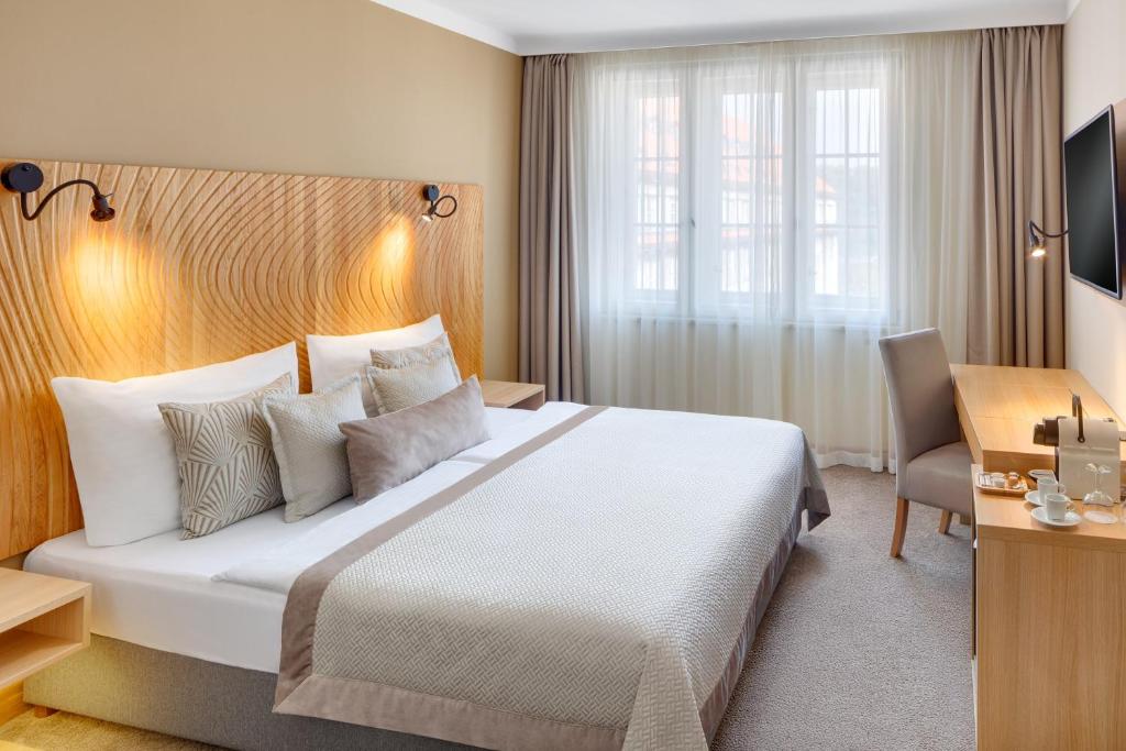 布拉格克莱门酒店的酒店客房设有一张大床和一张书桌。