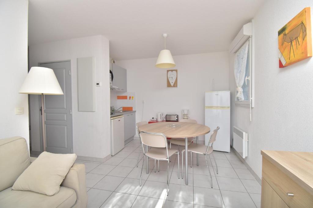 勒格罗-迪鲁瓦T2 Résidence Cap Camargue avec piscine的厨房以及带桌椅的起居室。