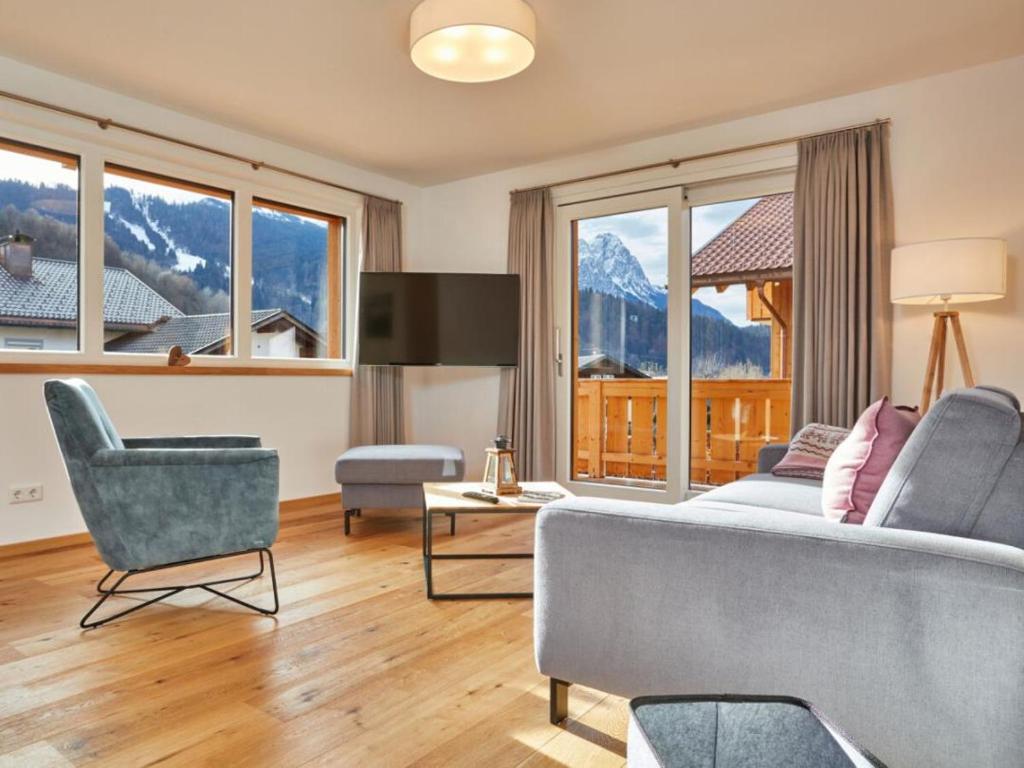 加尔米施-帕滕基兴Fewo Sterntaler OG in Garmisch-Partenkirchen的带沙发、椅子和窗户的客厅