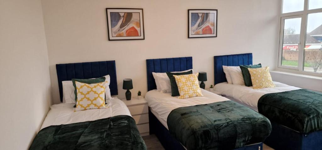 弗特威克Flitwick Luxury Apartment - Sleeps 4的一间设有三张床和枕头的客房