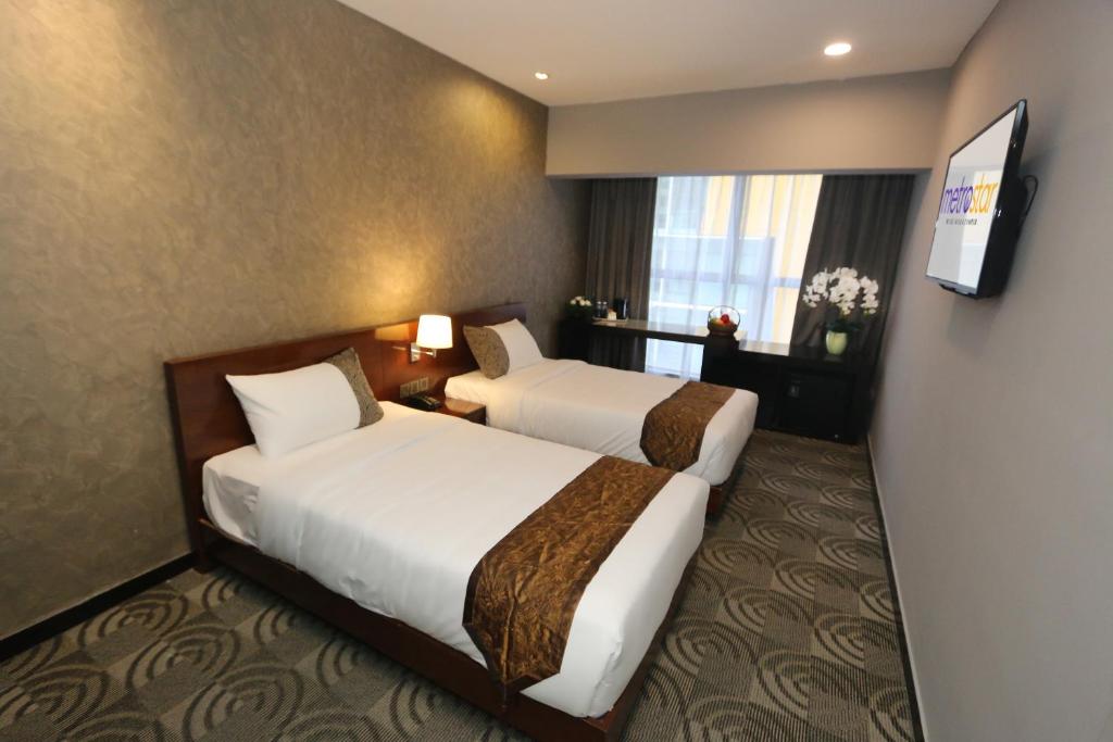 吉隆坡Metrostar Hotel Kuala Lumpur的酒店客房设有两张床和电视。