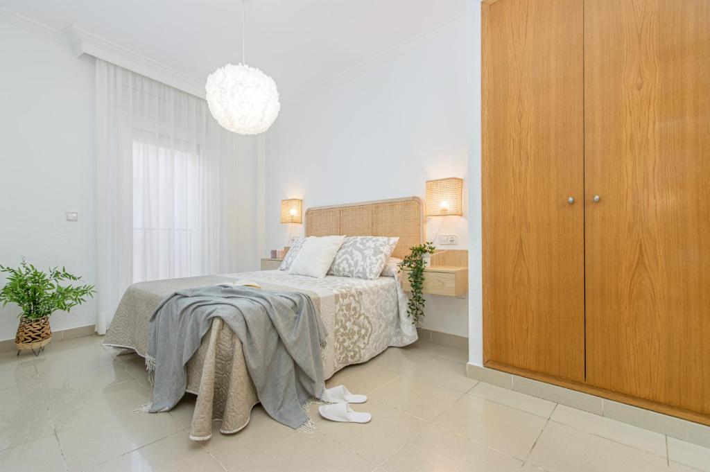 罗萨斯BADIA DE ROSES 1 new apartment的一间卧室配有一张床和一个木制橱柜