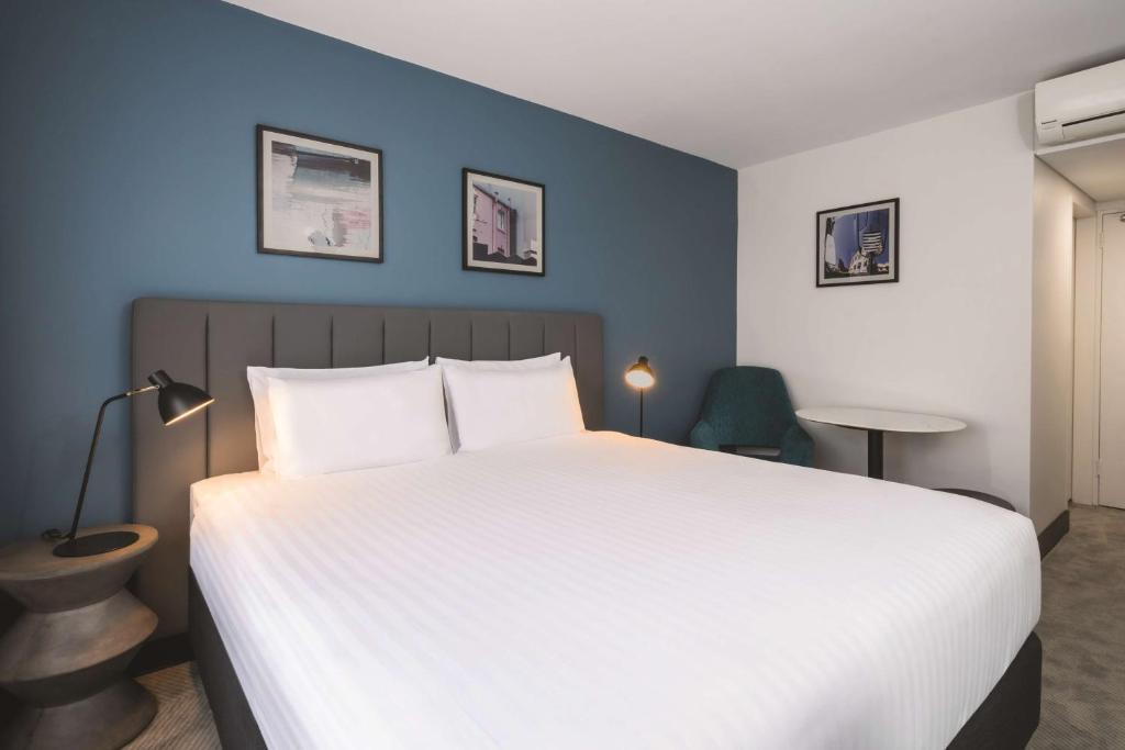 霍巴特霍巴特旅客之家酒店的卧室配有白色的床和蓝色的墙壁
