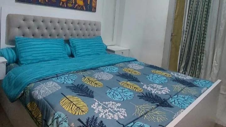 PulosirihMaxxy room grand Kamala lagoon的一间卧室配有一张蓝色和黄色的床罩