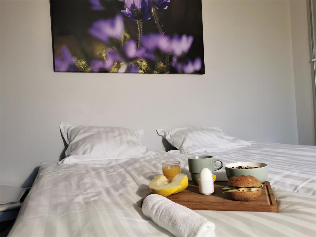 利雪平Broholm Bed&Breakfast的床上装有食物和两杯咖啡的托盘