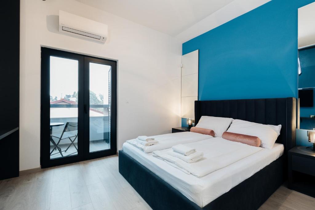 梅杜林Boutique Suites Joyce Medulin with free parking的一间卧室设有一张蓝色墙壁的大床