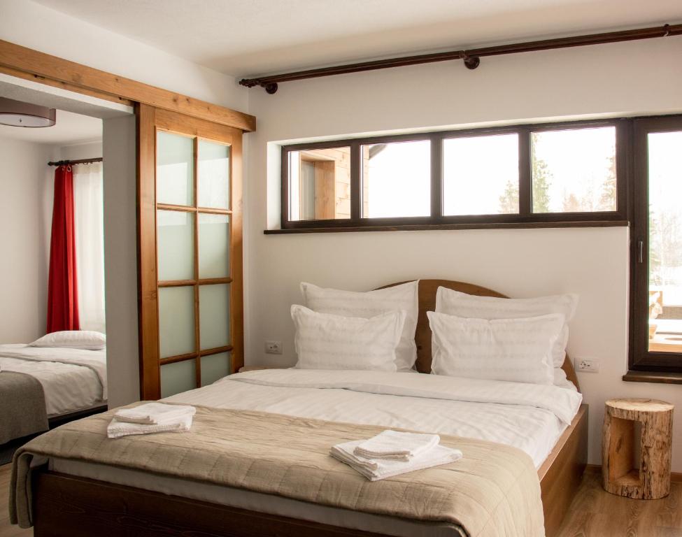 苏恰瓦Chalet Deluț的一间卧室配有两张带白色枕头的床和窗户。