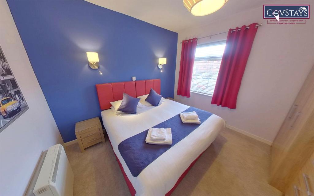 考文垂Sunnyside View - 1-bed Apartment in Coventry City Centre的一间卧室设有一张大床,拥有蓝色和红色的墙壁