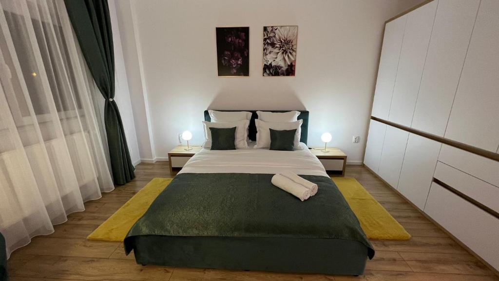 克卢日-纳波卡Aparthotel Junior4 Cluj的一间卧室配有一张大床和两盏灯。