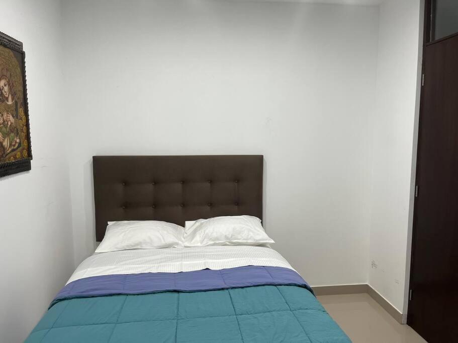 伊察Apartamento en Ica 3的一间卧室配有一张带蓝白色毯子的床