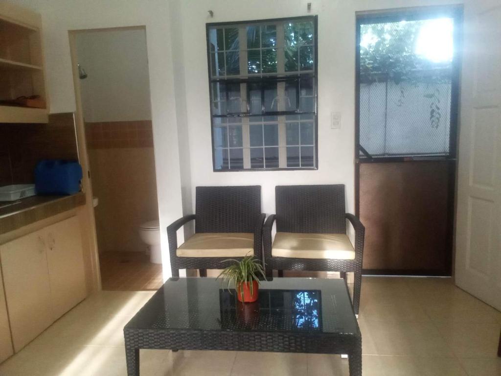 卡加盐德奥罗Kendall Place Apartment的客厅配有两把椅子和一张桌子