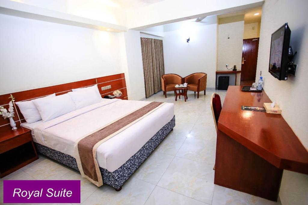 库克斯巴扎Royal Beach Resort的酒店客房配有一张特大号床和一张书桌